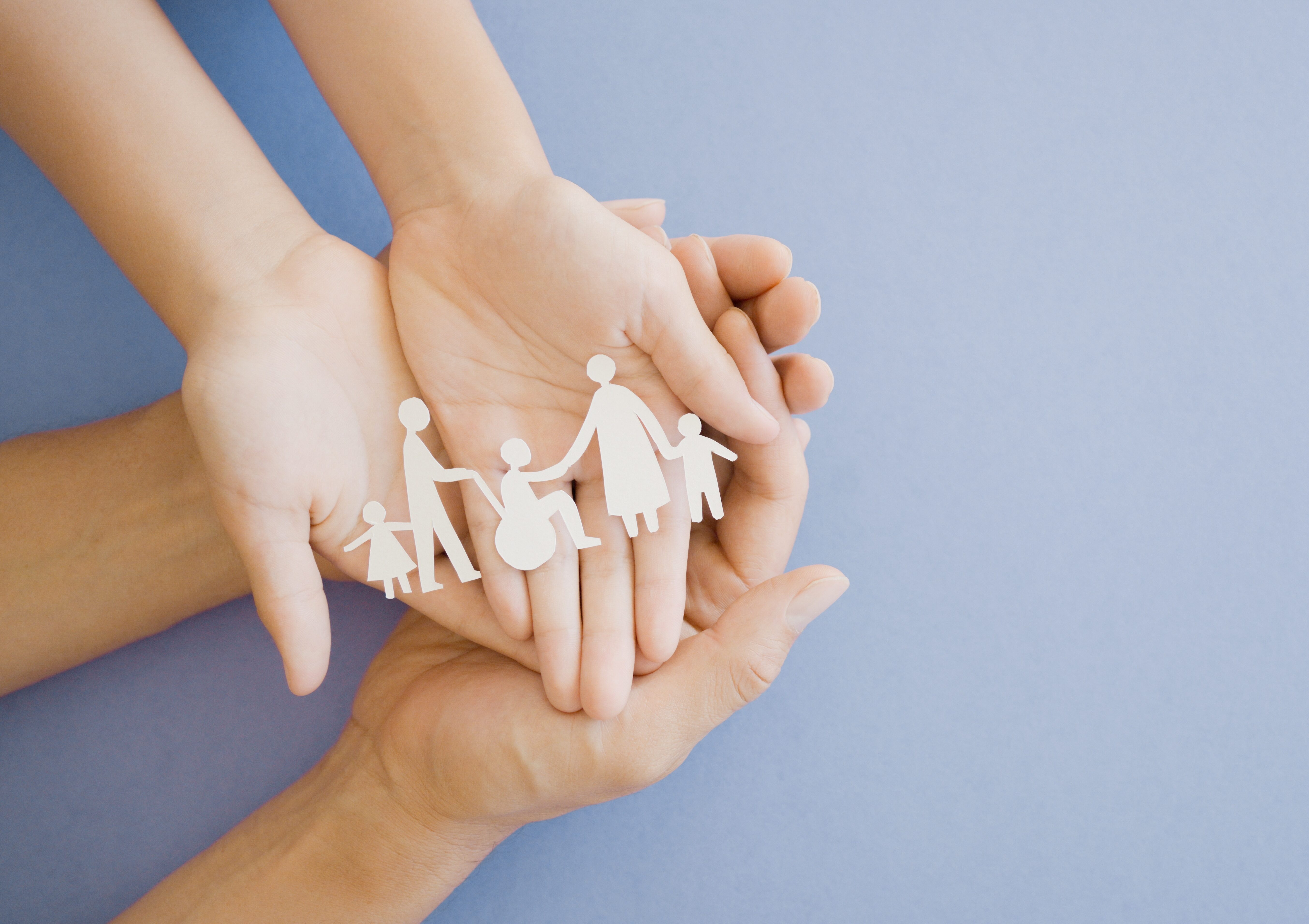 Three hands holding paper cut out of people